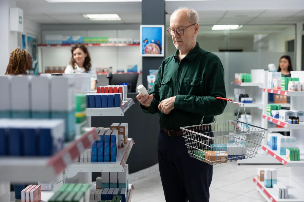 Pessoa idosa escolhe medicamento em farmácia para ilustrar gastos que podem ser descontados da renda do BPC